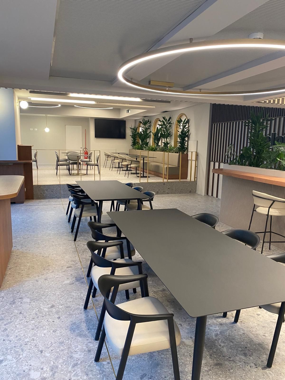 Ci sono molti tavoli e sedie in questa stanza.