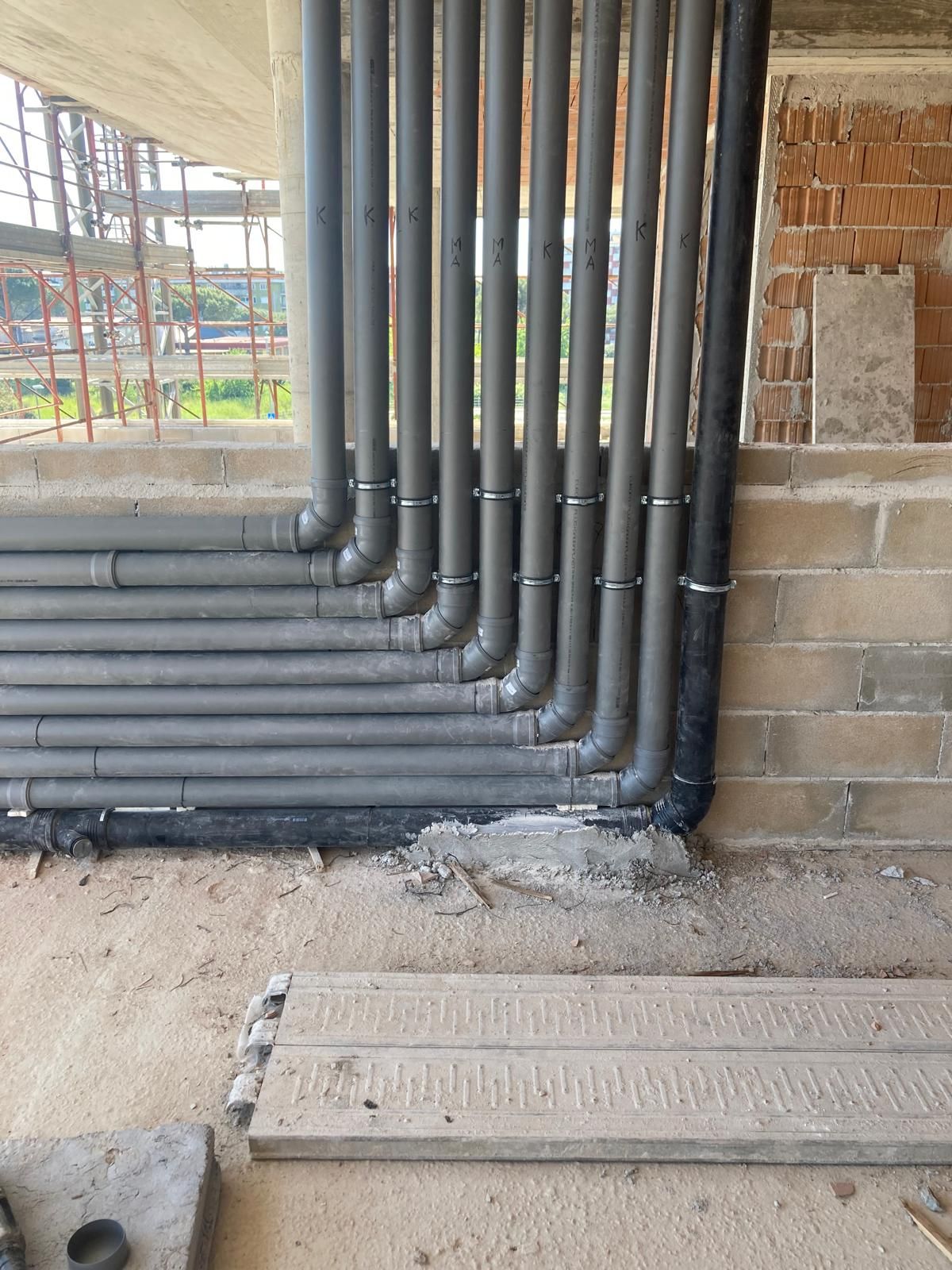 Un mucchio di tubi sono collegati a un muro in un edificio in costruzione.