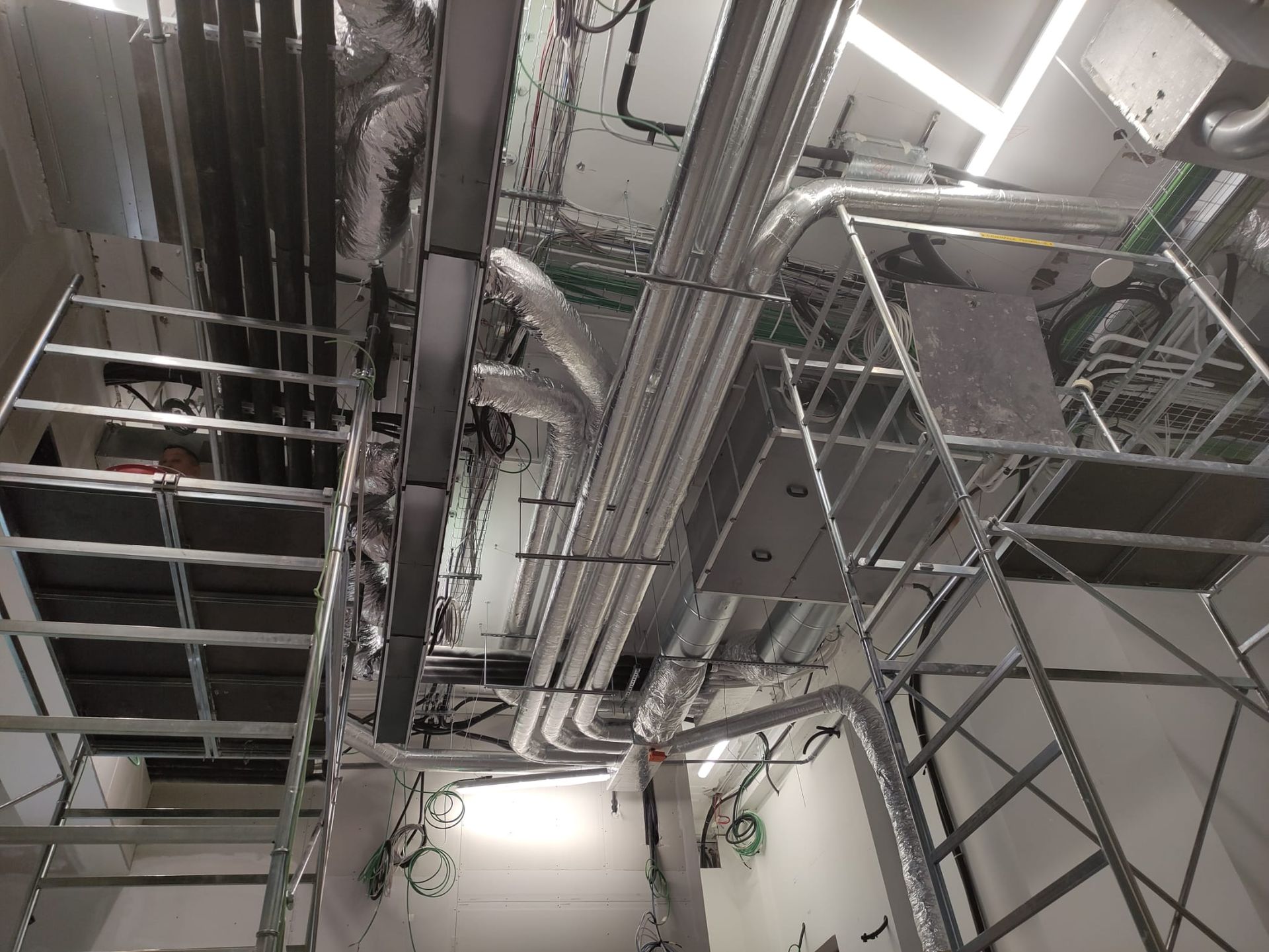 Una stanza con un sacco di tubi che pendono dal soffitto.