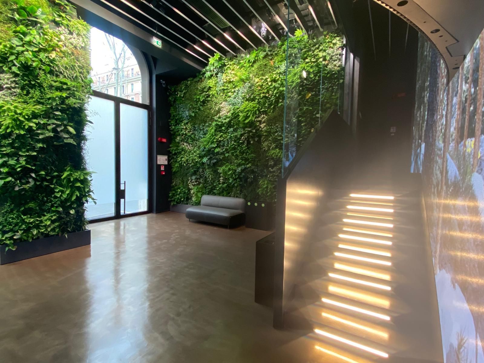 C'è un divano in mezzo a una stanza con una parete verde.