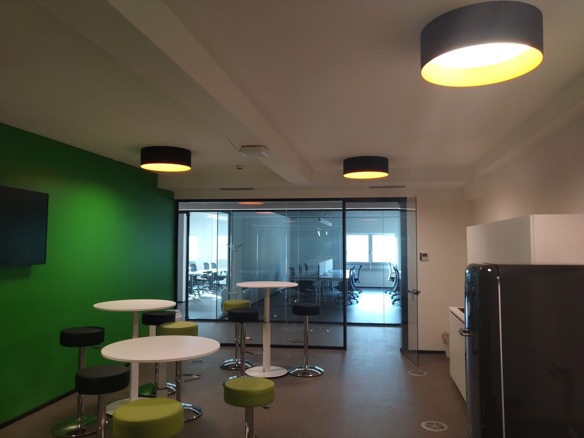 Una stanza con tavoli e sedie e una parete verde