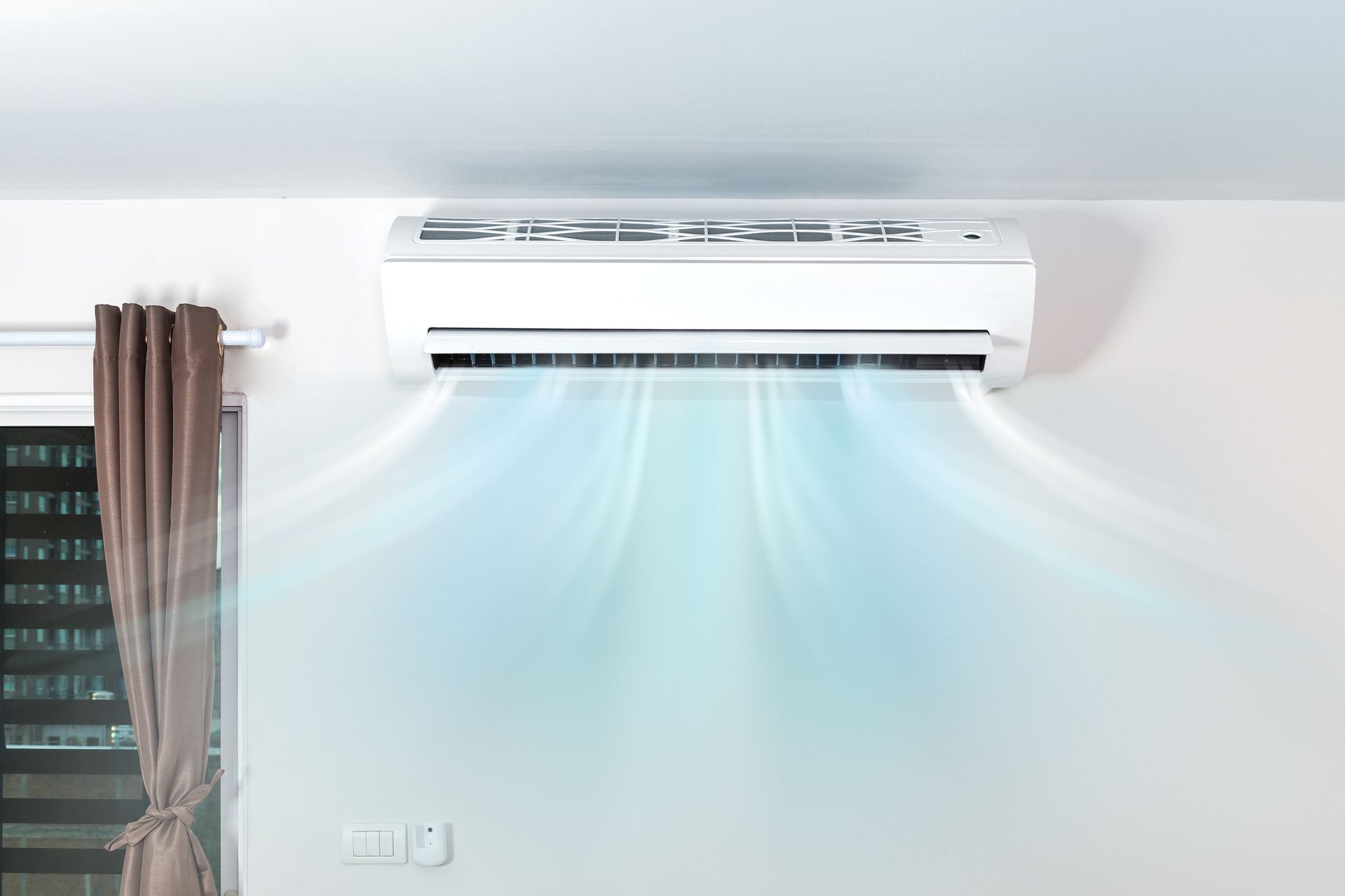 White air conditioner blowing cool air in a room.