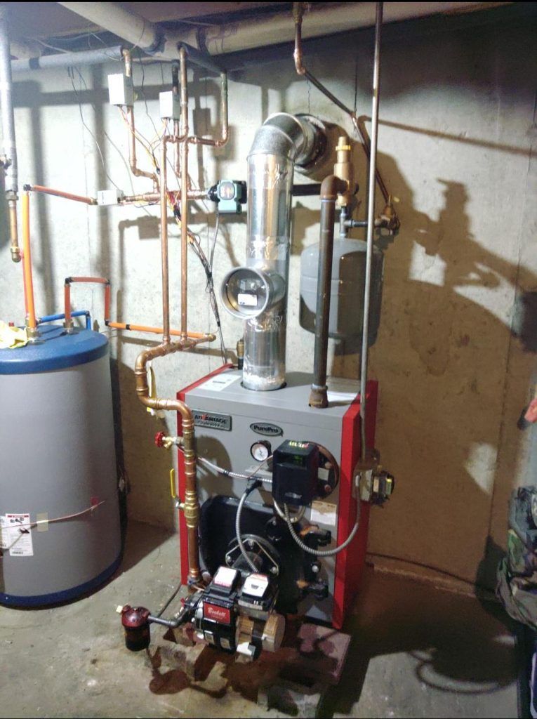 A residential boiler system in a basement setting. Includes a water heater, copper pipes, and a flue.