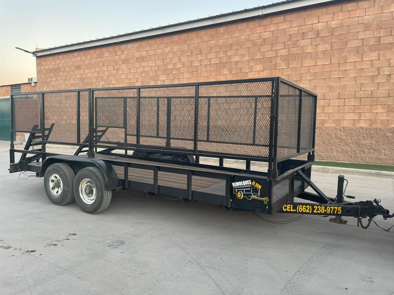Un remolque está estacionado frente a un edificio de ladrillos.