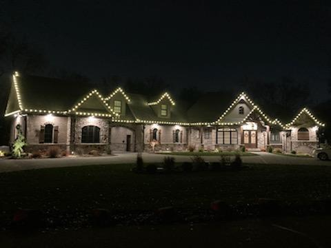 a large house is lit up with christmas lights at night — Louisville, OH — Mongiardo Power Wash