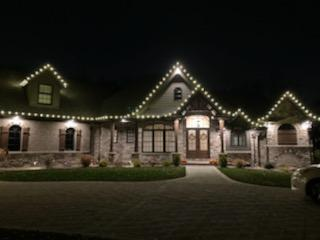 a large house with christmas lights on it is lit up at night — Louisville, OH — Mongiardo Power Wash