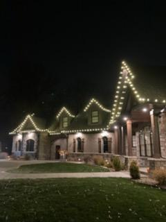 a house with christmas lights on the roof at night — Louisville, OH — Mongiardo Power Wash