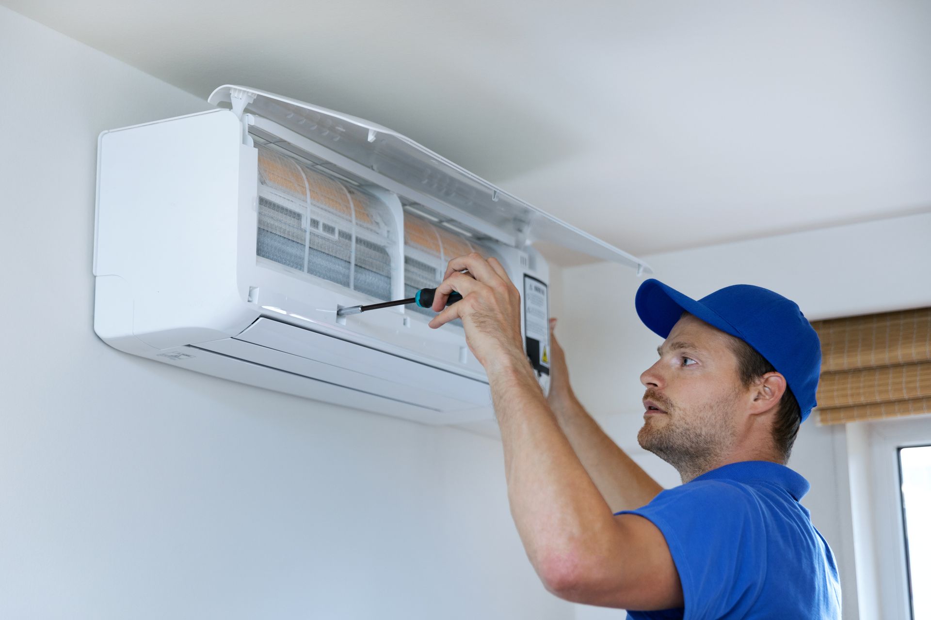 A home air conditioning contractor repairing the unit.