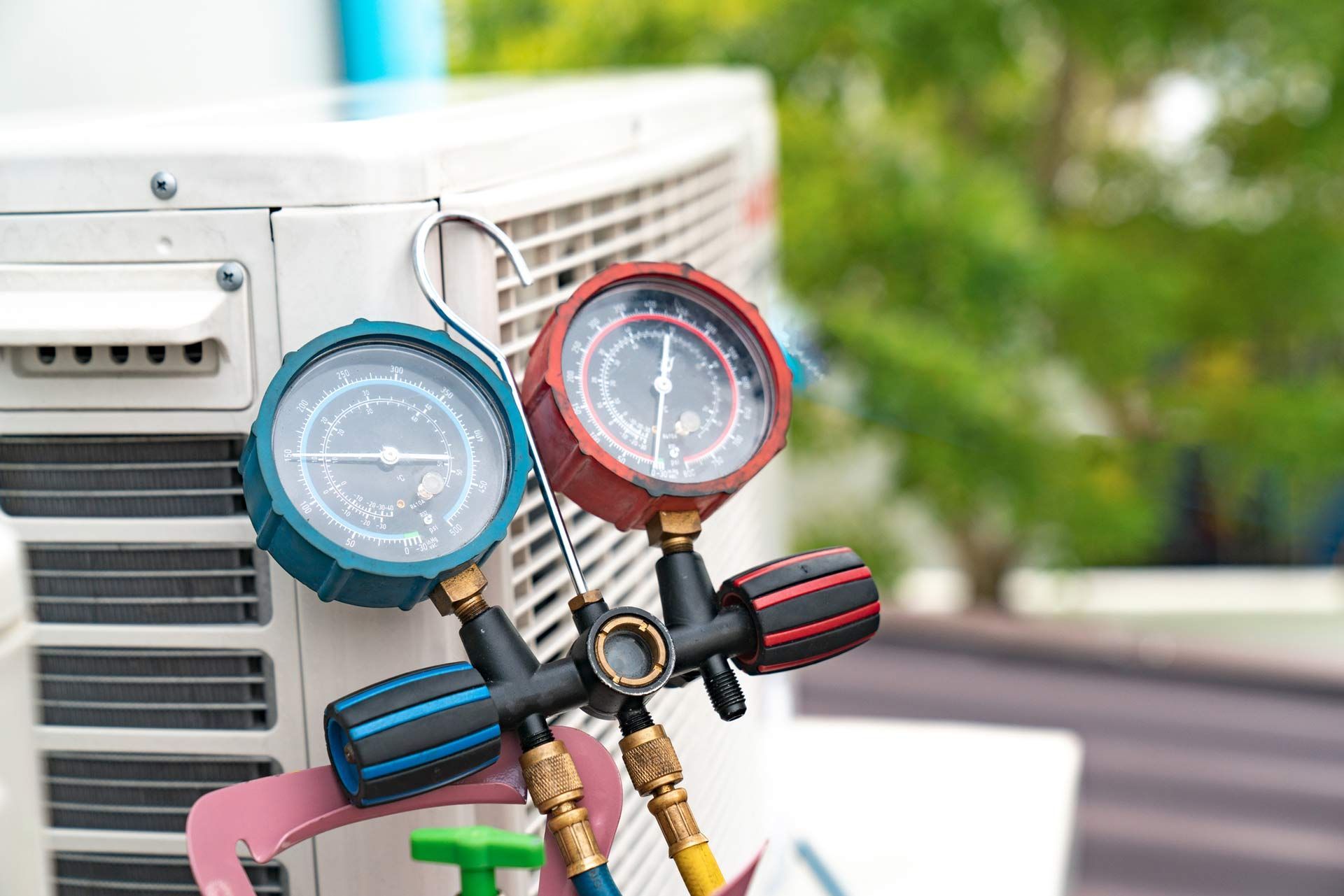 A couple of gauges hanging on the side of an air conditioner.