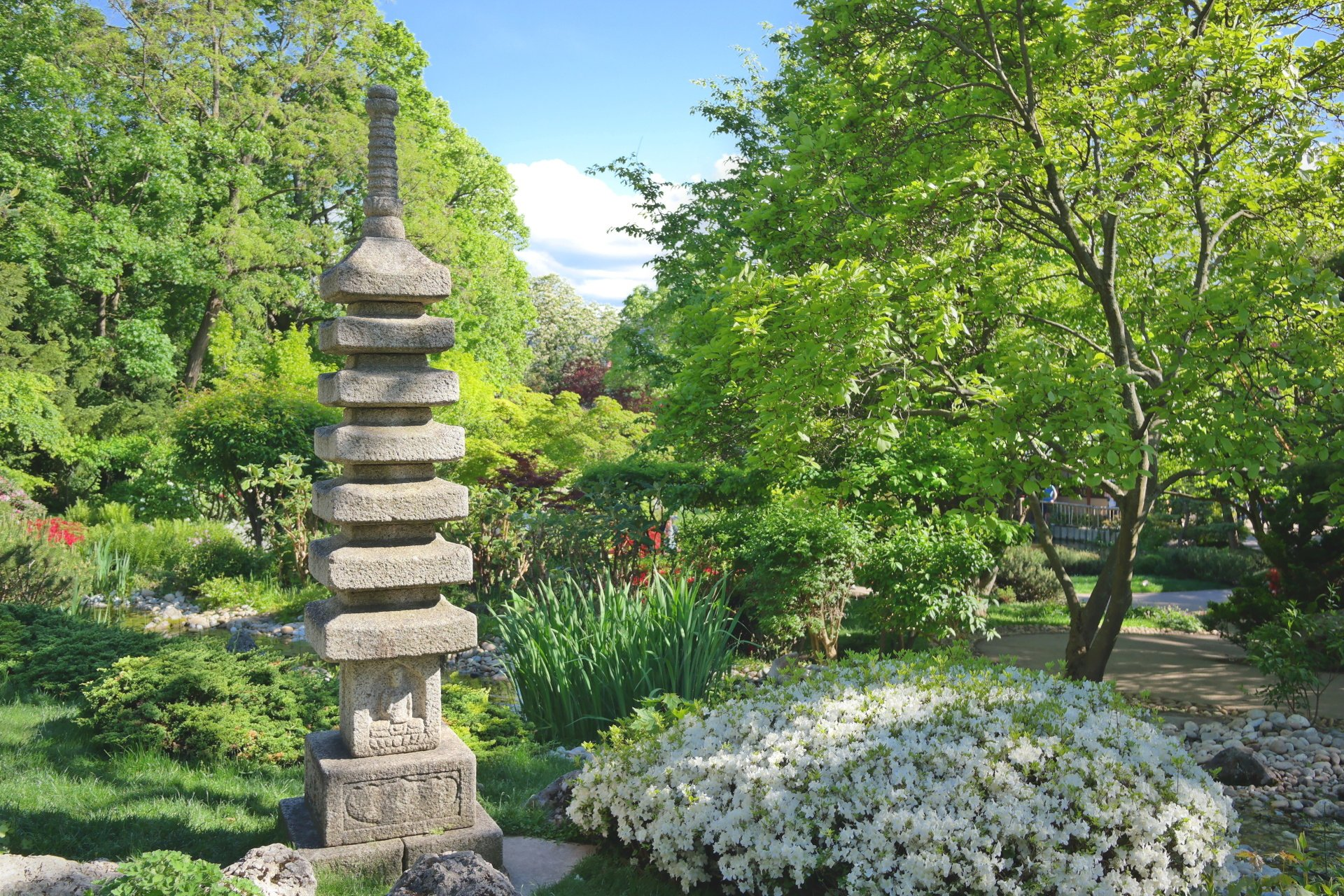 Steinmonument umgeben von Pflanzen im Setagayapark in Wien.