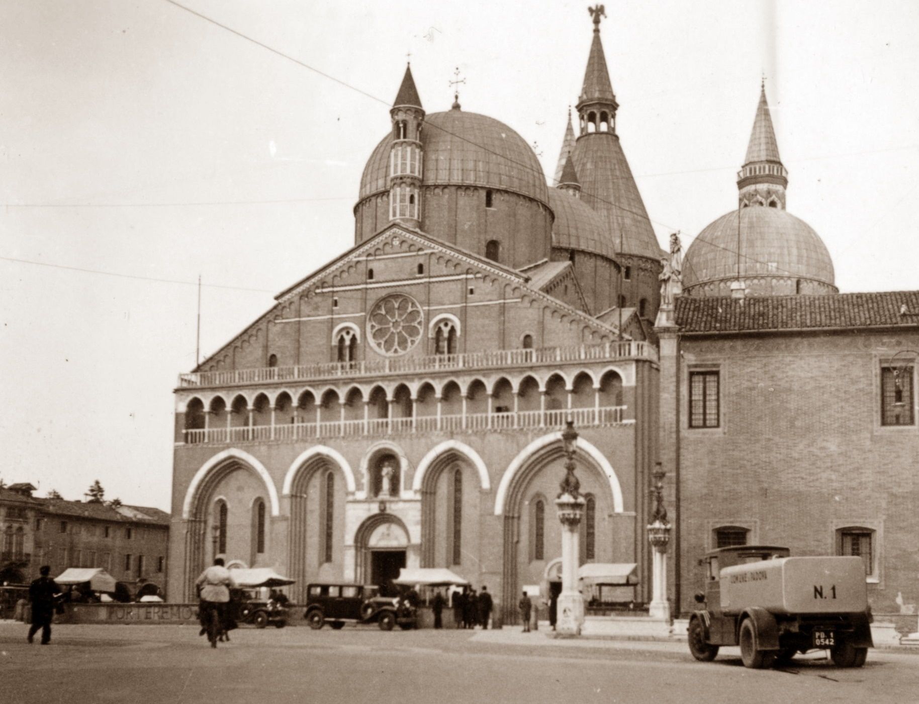 A black and white photo of a church with a truck parked in front of it