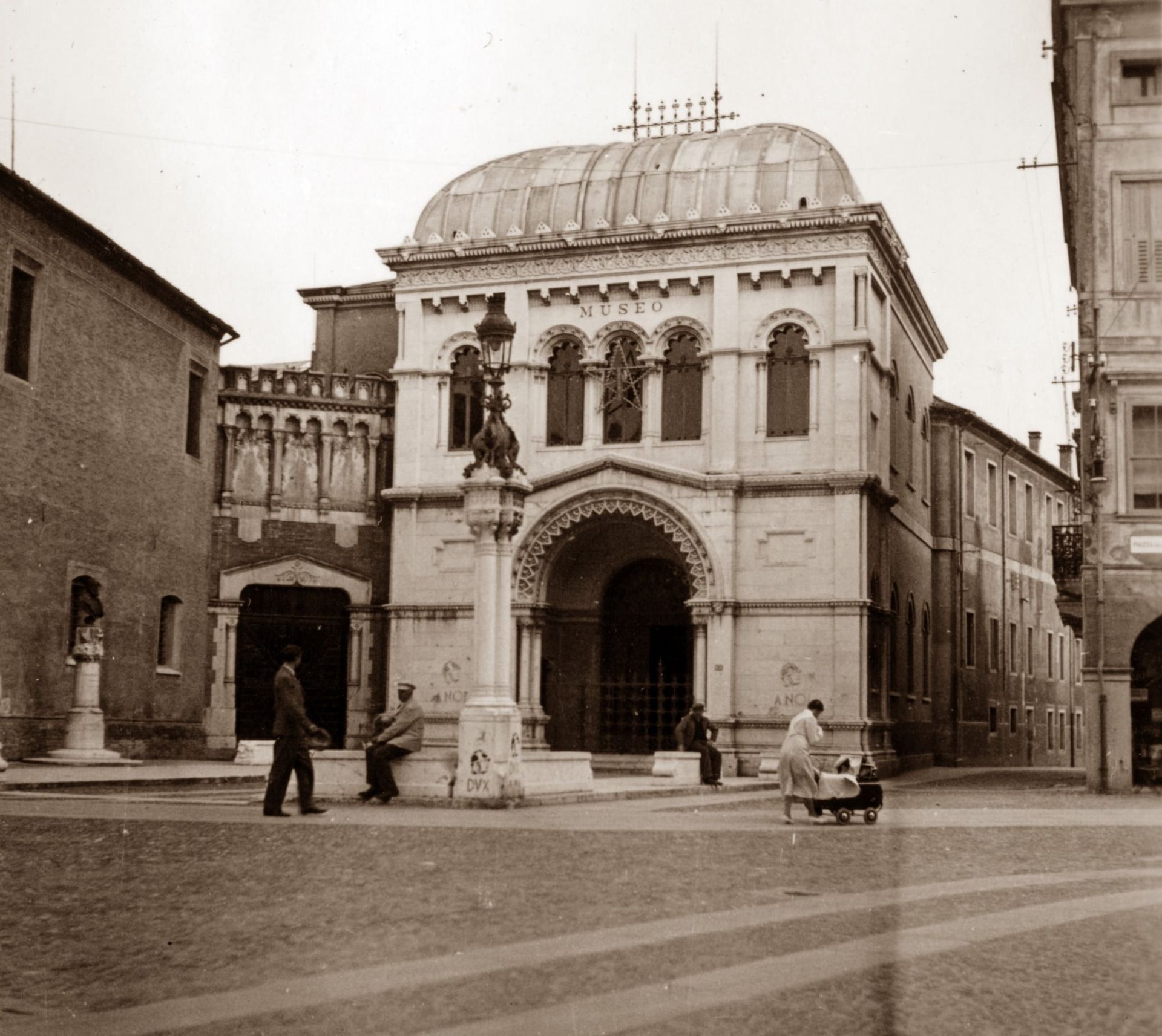 A black and white photo of a building with a dome on top