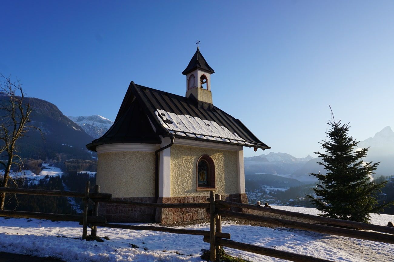 A small church with a bell tower in the mountains