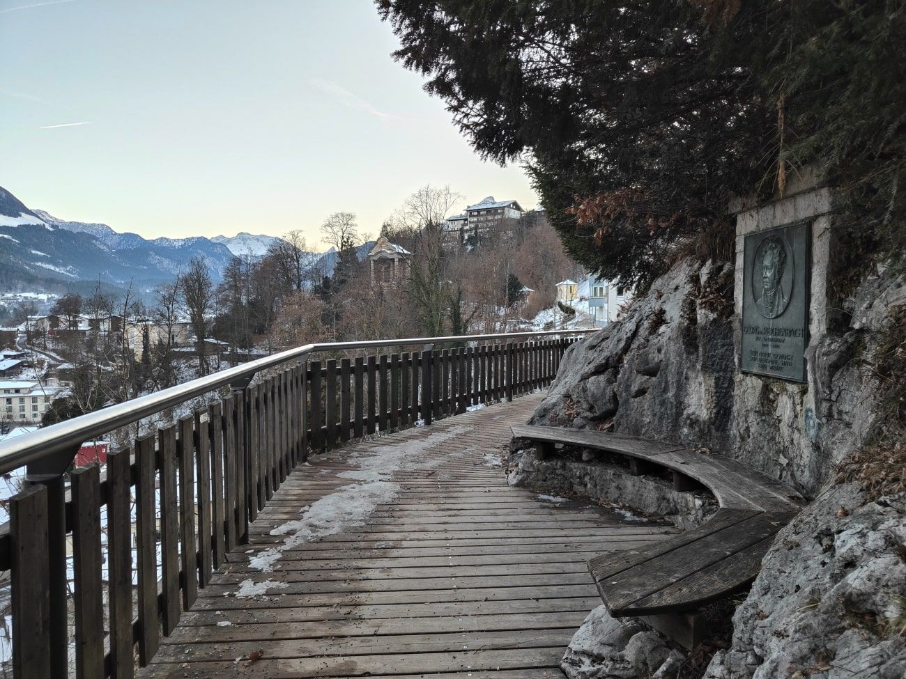 A wooden walkway with a fence and a bench