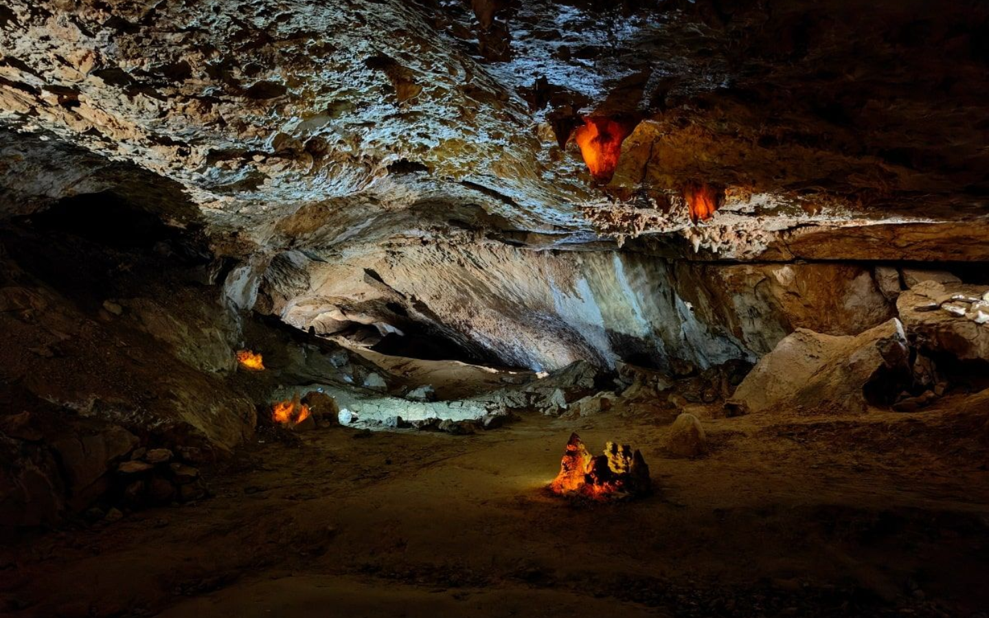 Dachstein Rieseneisenhöhle Dark cave interior with rock formations, lit by warm lights.