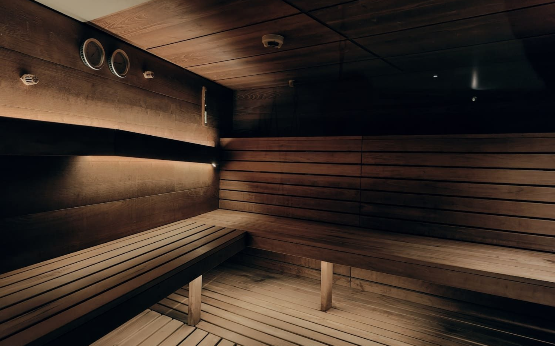 Wooden sauna interior with benches, dimly lit.