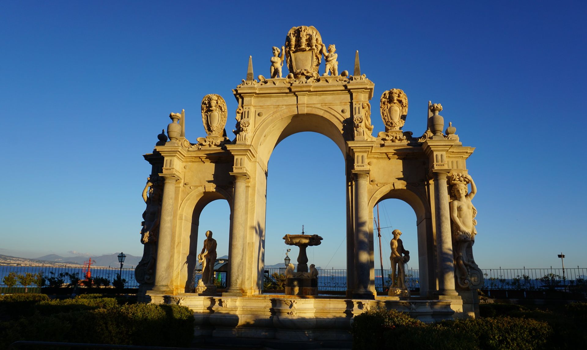 A large stone archway with a fountain in the middle