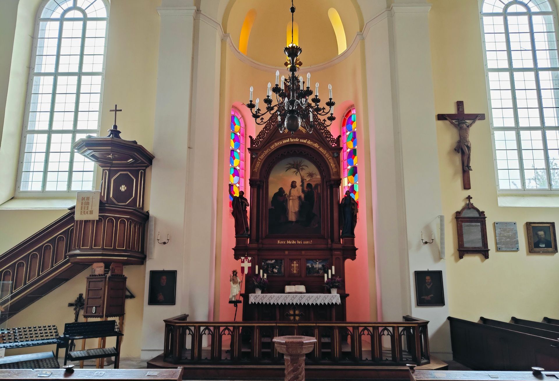 The inside of a church with a large altar and stained glass windows