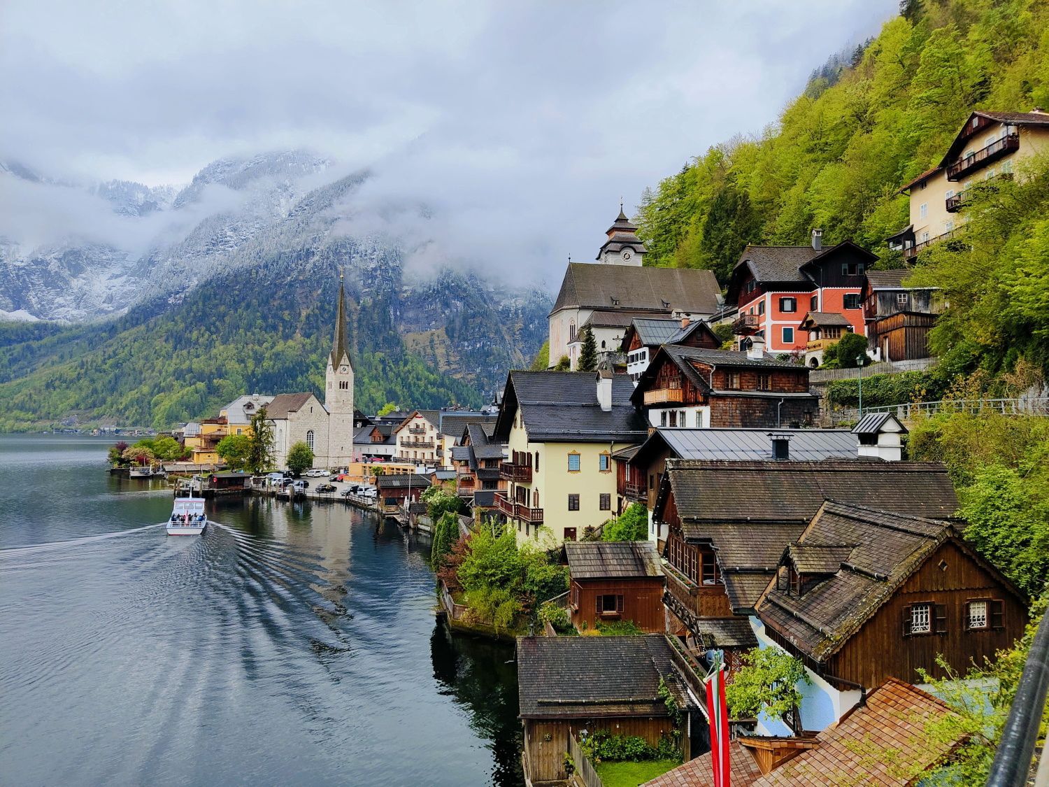 Hallstatt: A small town sits on the shore of a lake with mountains in the background