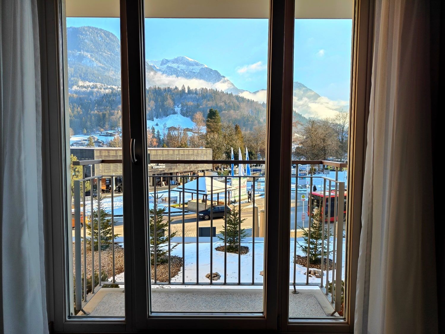 A balcony with a view of mountains and trees.