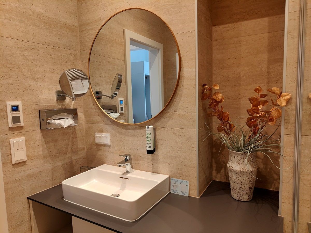 A bathroom with a sink and a round mirror