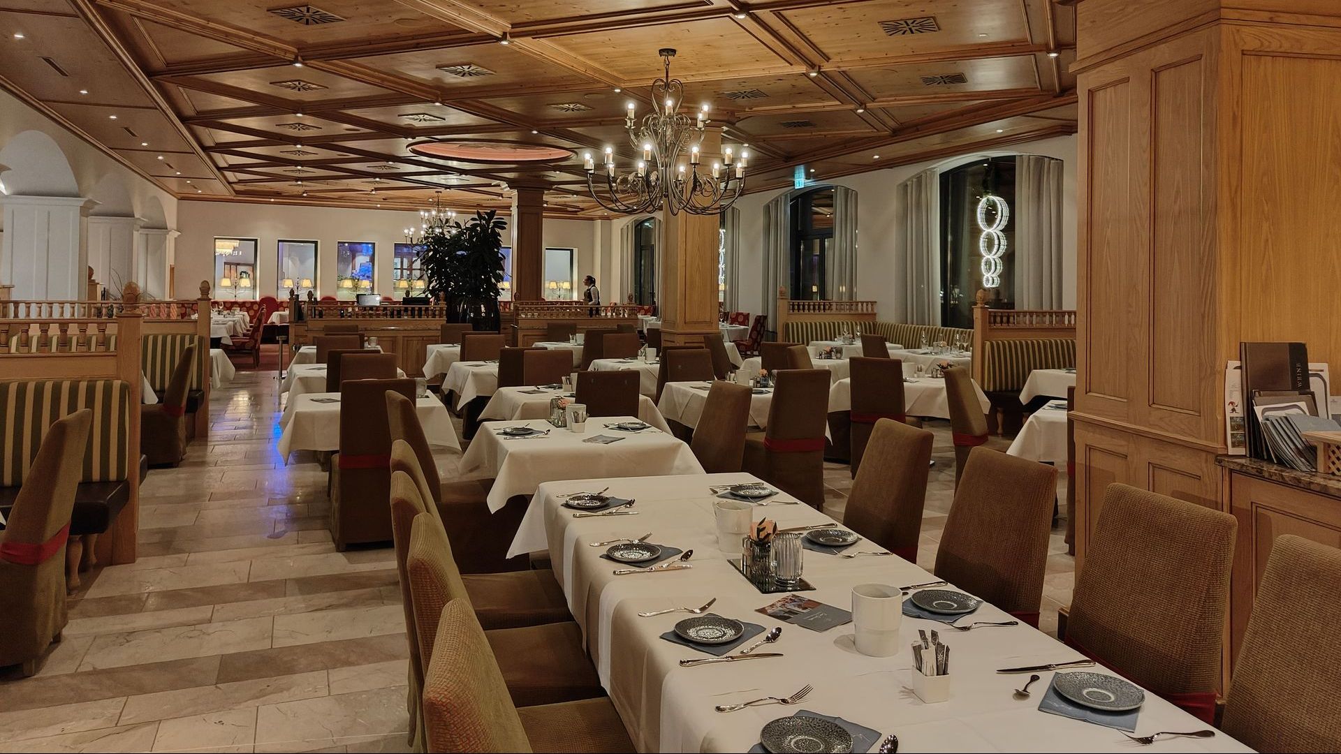 A large dining room with tables and chairs and a chandelier