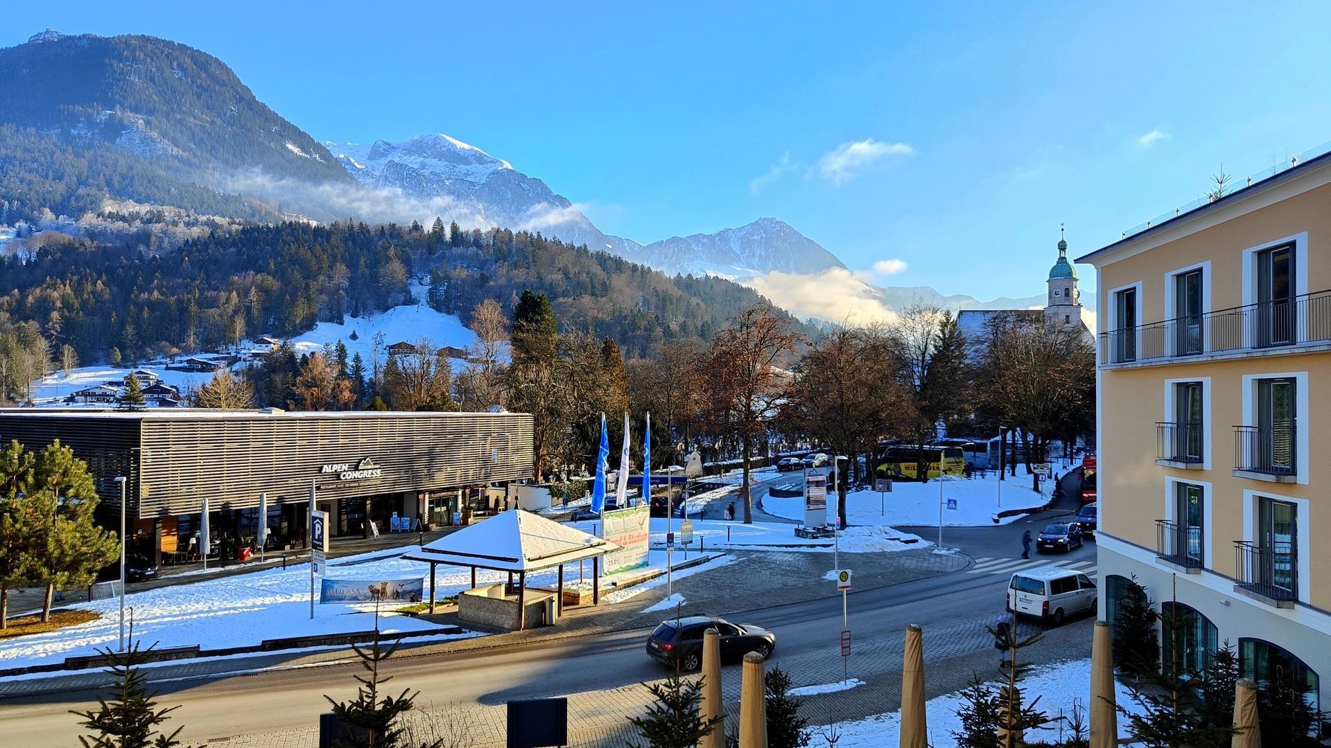 A large building in a snowy area with mountains in the background