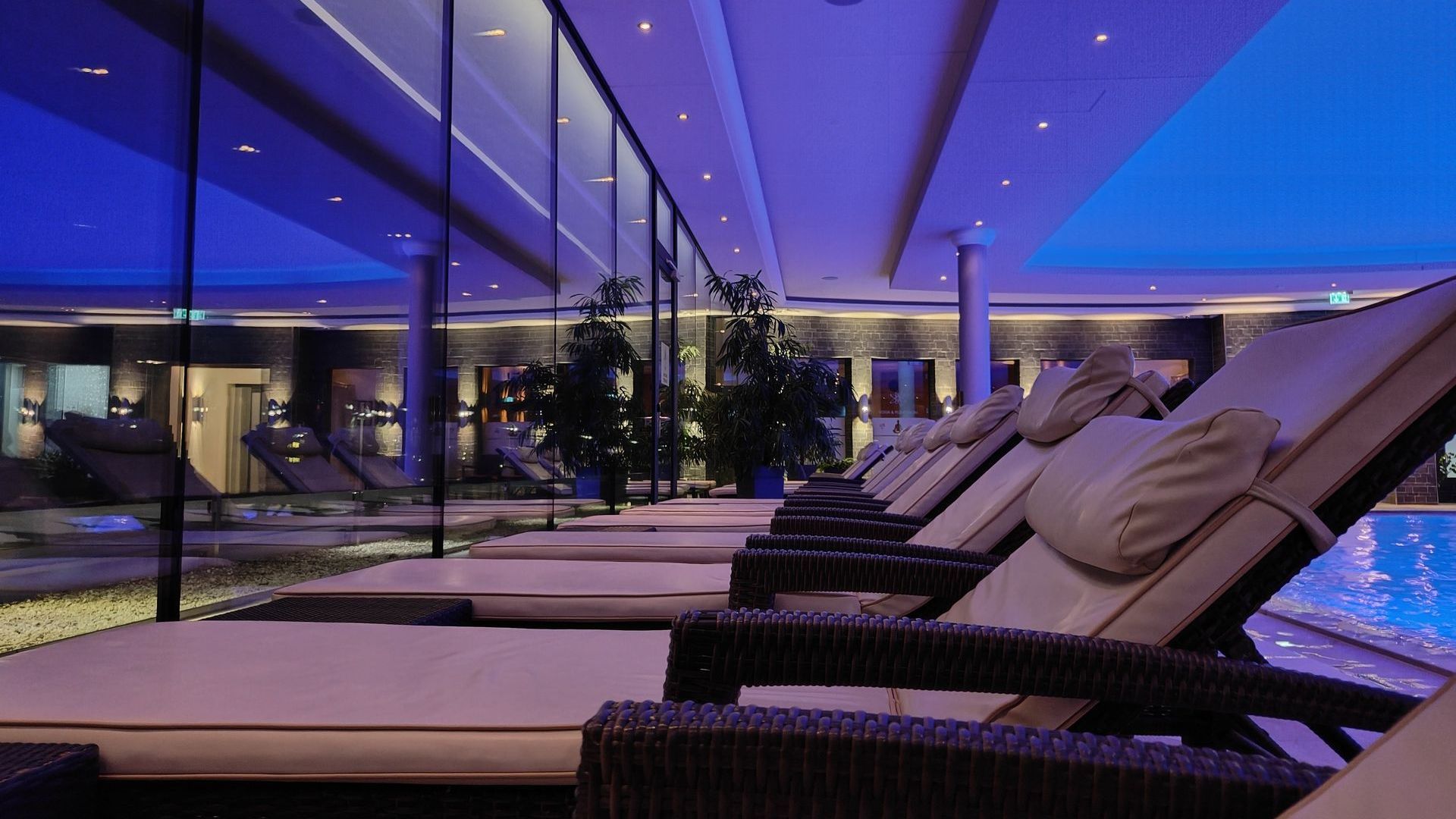 A row of lounge chairs in front of a swimming pool