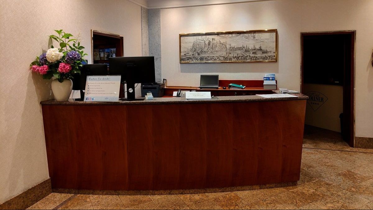 A reception desk in a hotel with flowers on it