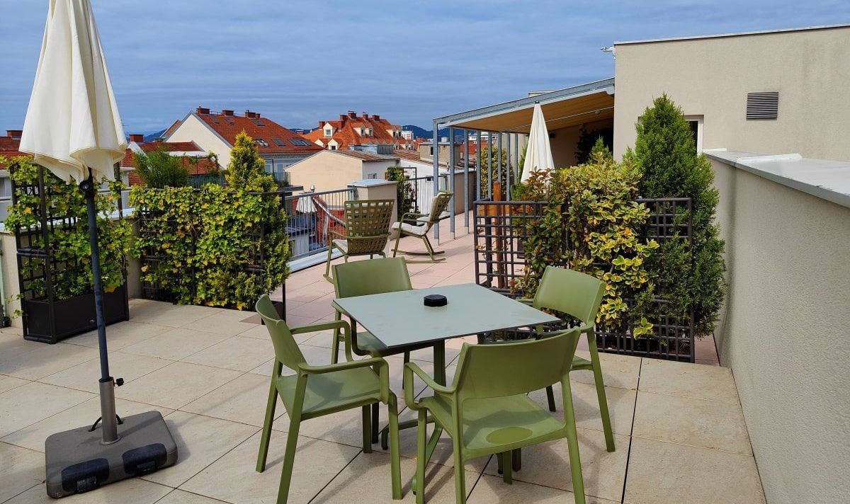 A patio with a table and chairs and an umbrella