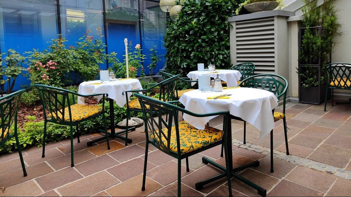 A patio with tables and chairs with yellow cushions