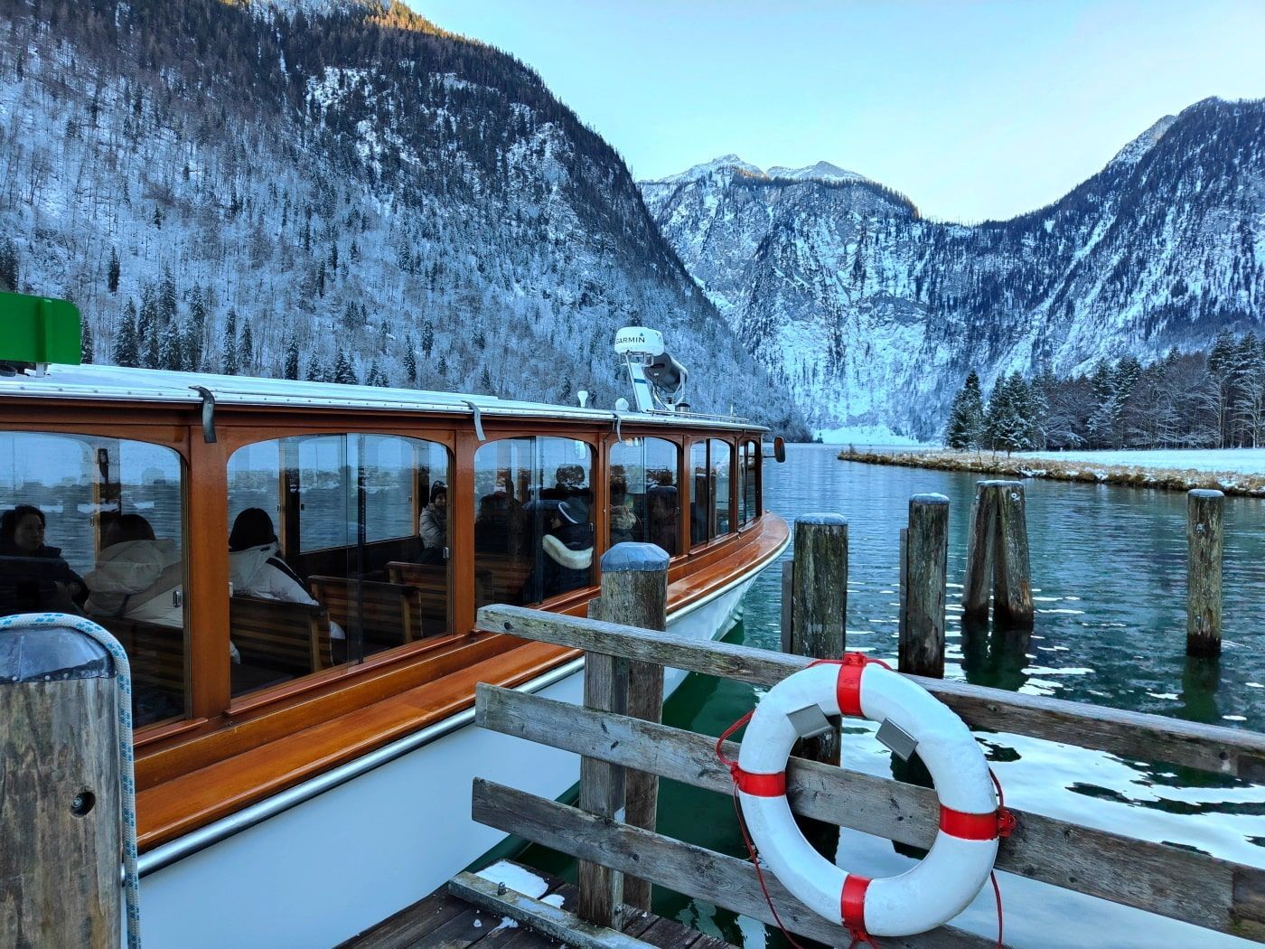 A boat is docked at a dock with mountains in the background