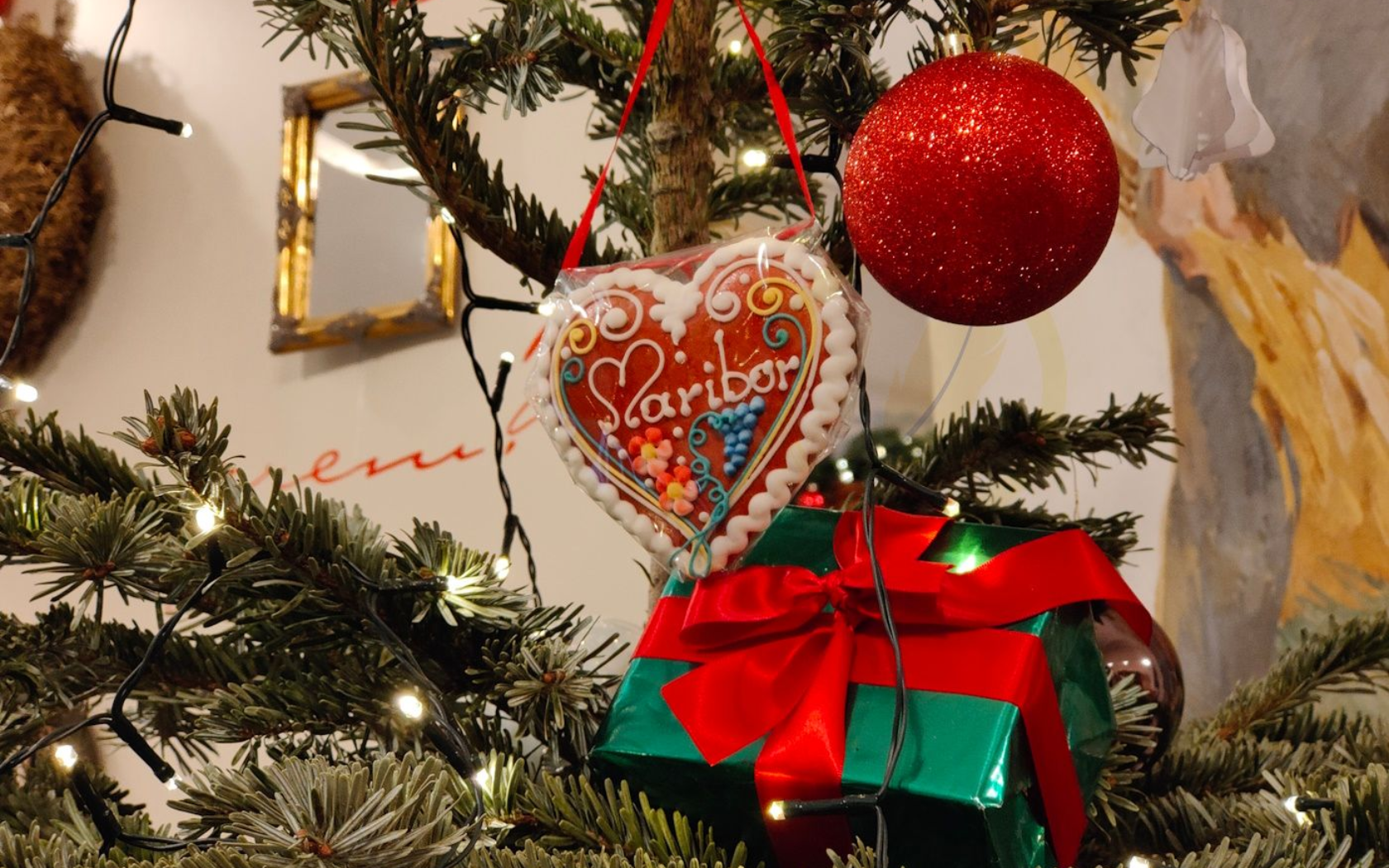 Maribor Weihnachten Christmas tree decorated with ornaments, including a heart-shaped cookie, red present, and sparkling ball.