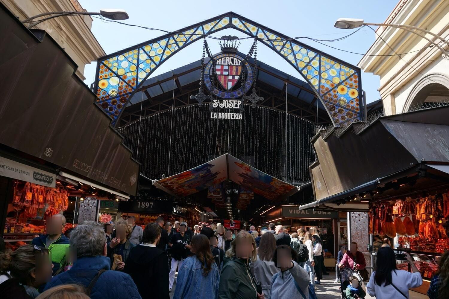 A crowd of people are gathered in front of a building that says ' barcelona ' on it