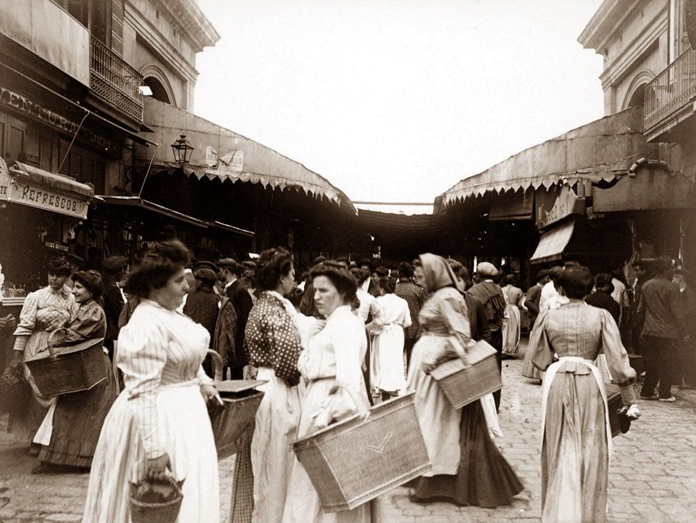 A black and white photo of women walking down a street