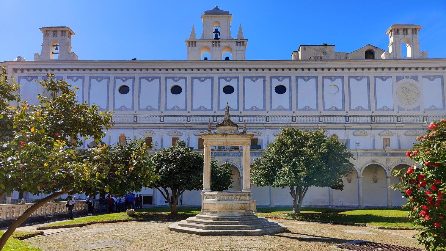 A large white building with a fountain in front of it