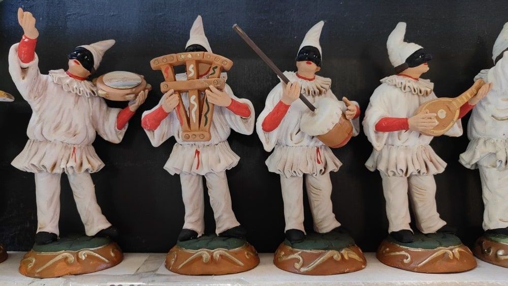 A group of figurines are standing in a row playing musical instruments