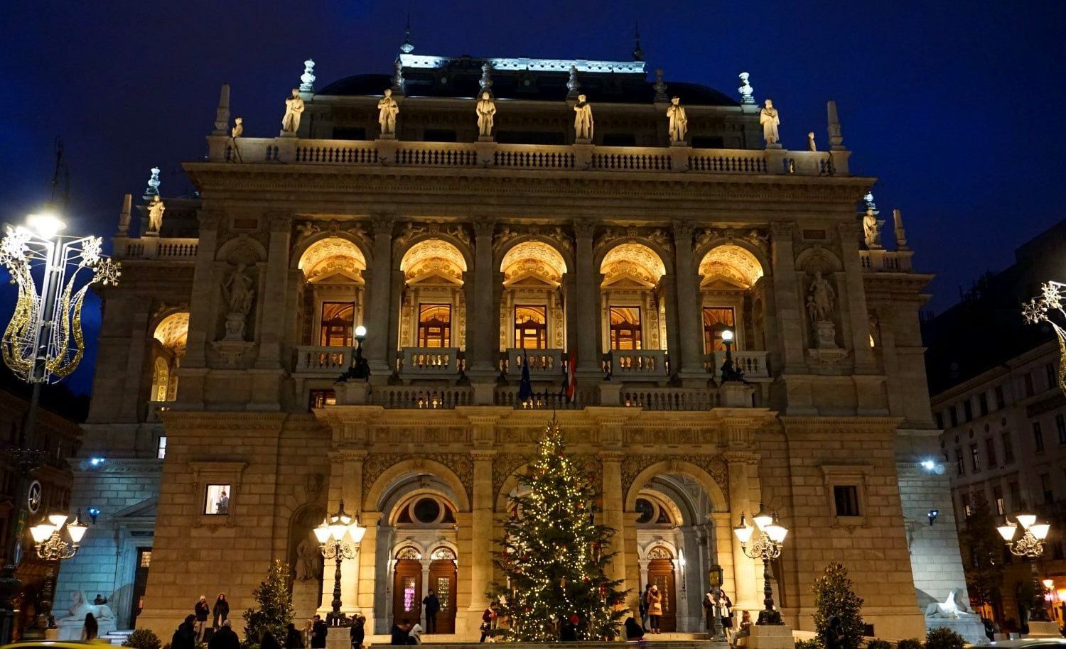 A large building with a christmas tree in front of it in Budapest (Weihnachten)