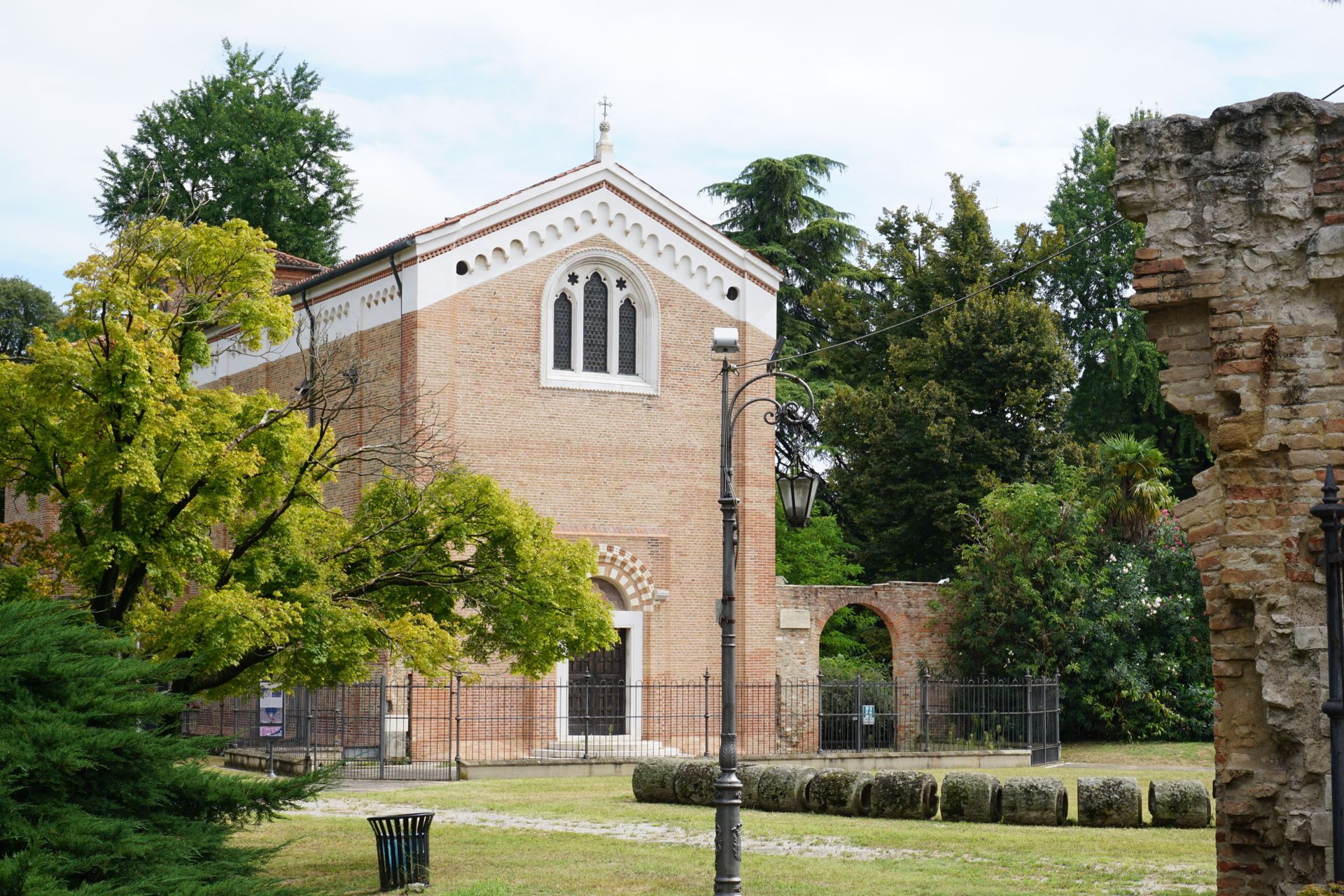 A brick building with a white trim is surrounded by trees