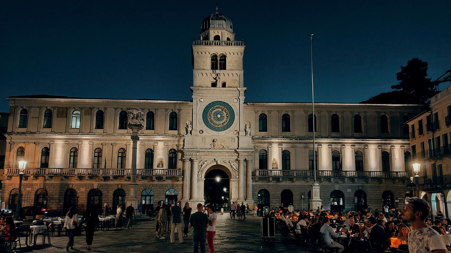 A large building with a clock on top of it in Padova.