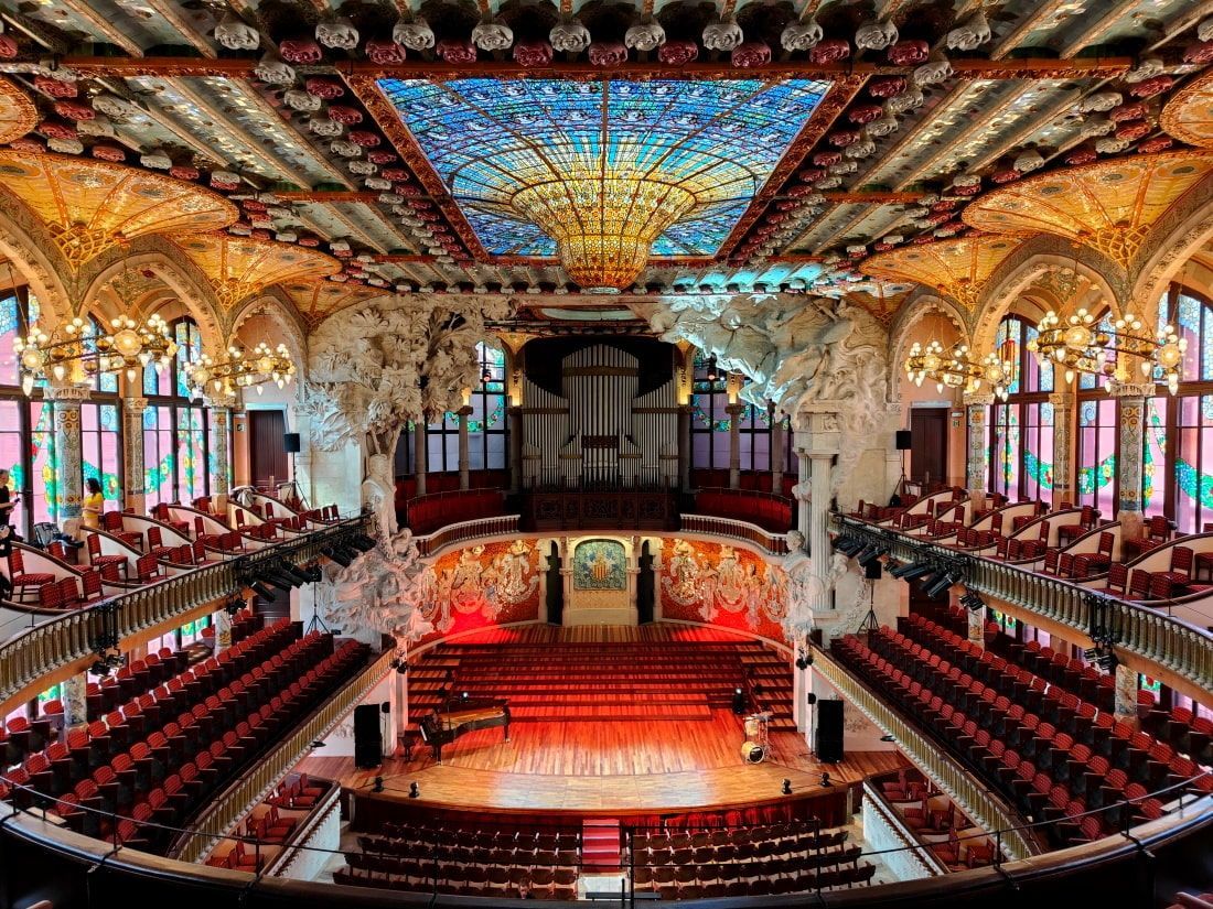 Palau de la Música Catalana Barcelona A large auditorium with red seats and a stained glass ceiling