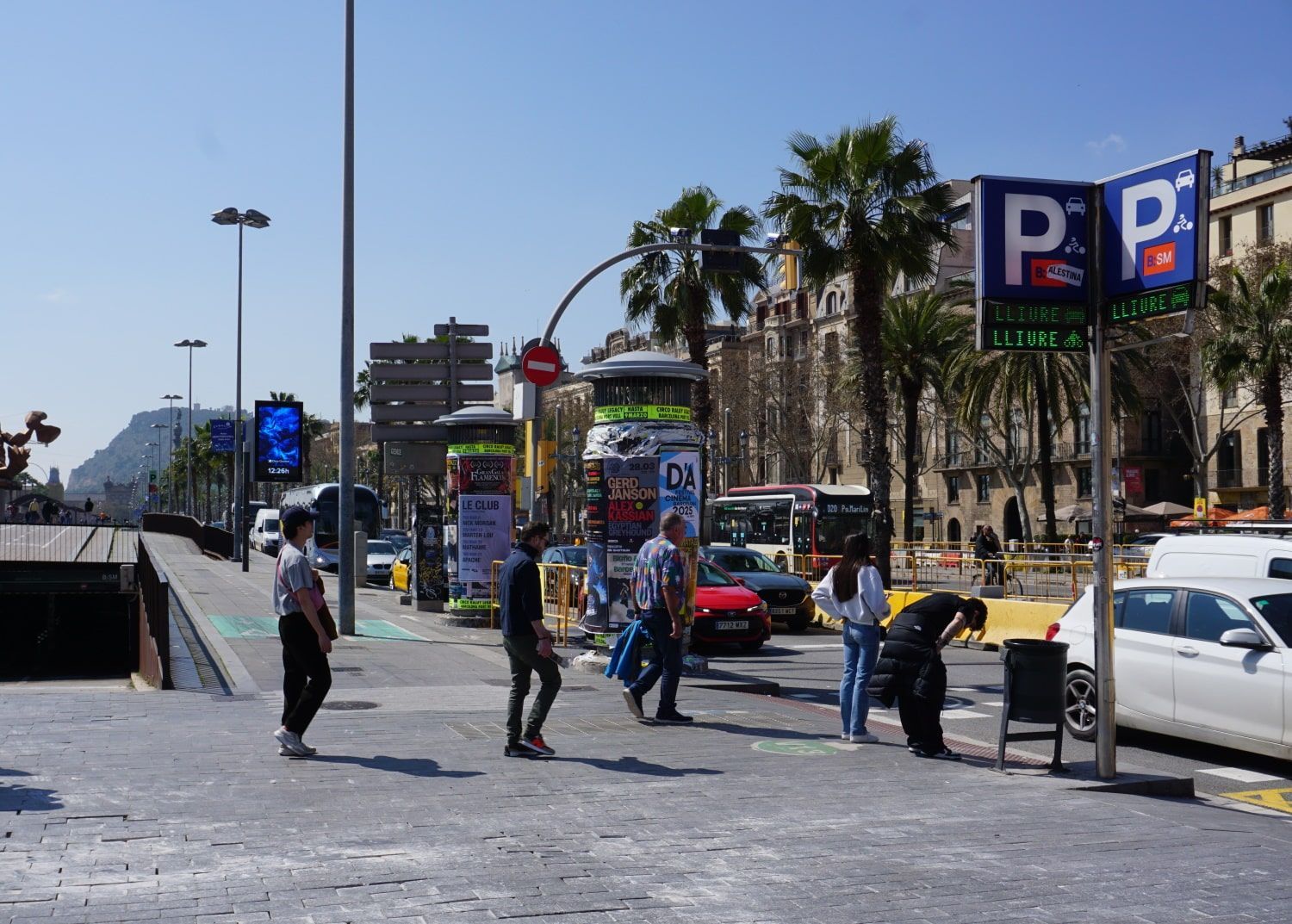 People walking in front of a parking sign that says p