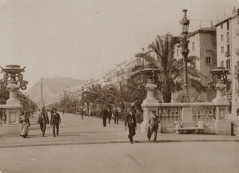A black and white photo of people walking down a street