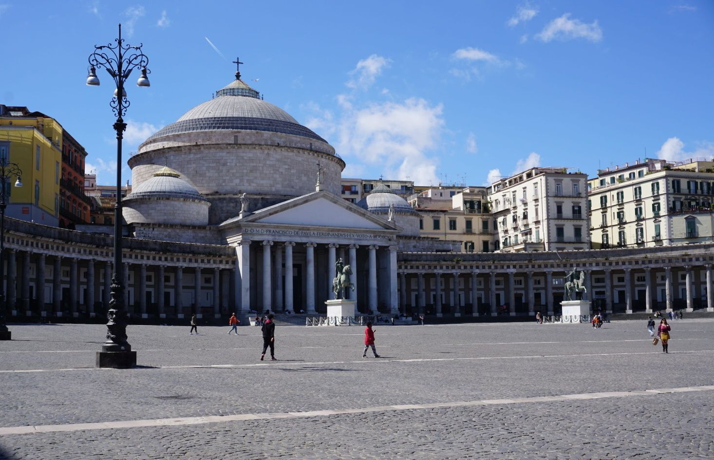 A group of people walking in front of a large building