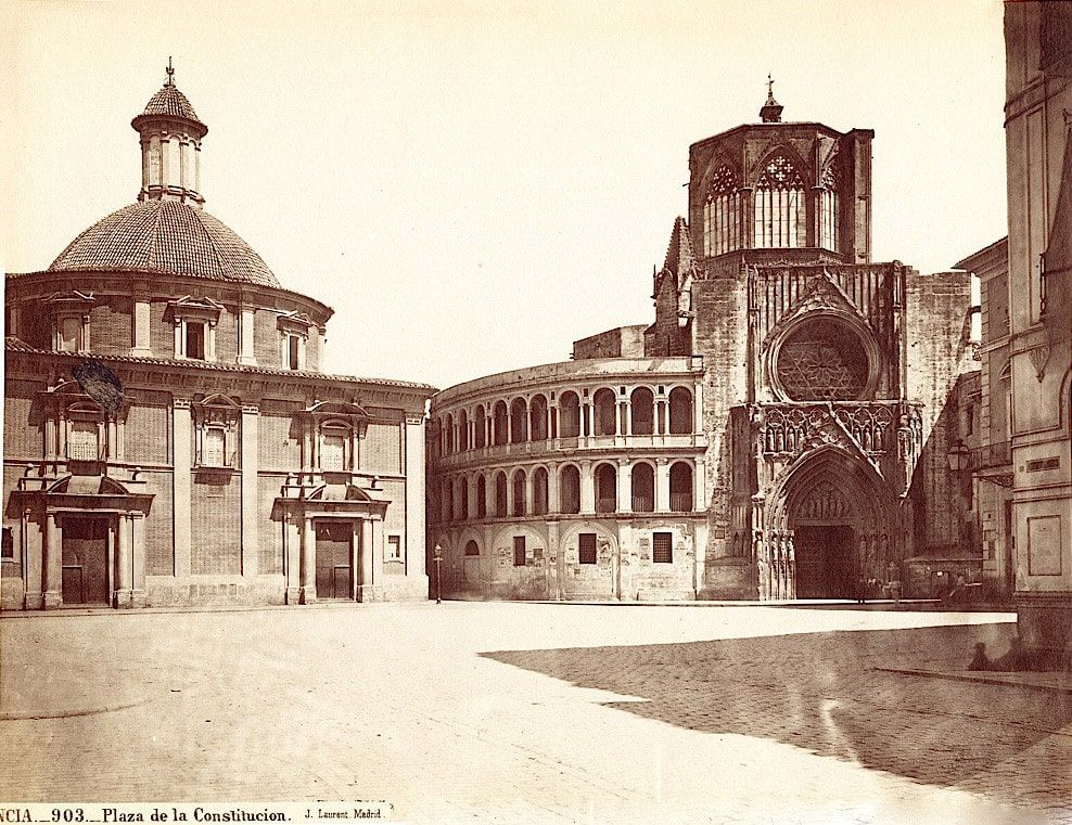 View of a plaza in Valencia, Spain, with the round dome of a church and a gothic cathedral.
