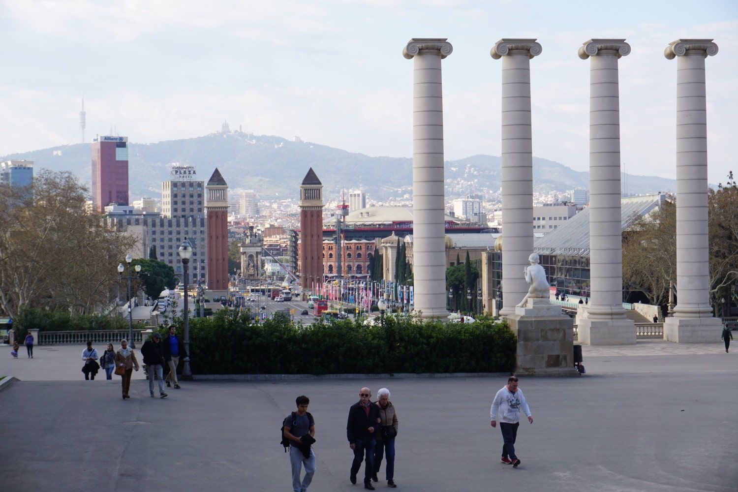 A group of people walking in front of a row of columns