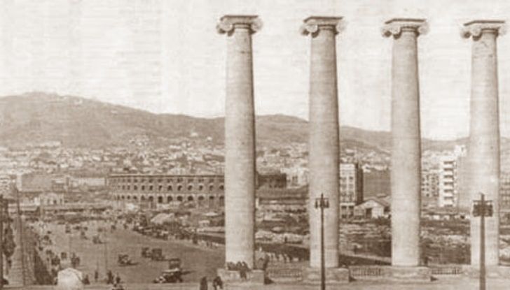 A black and white photo of a city with columns in the foreground
