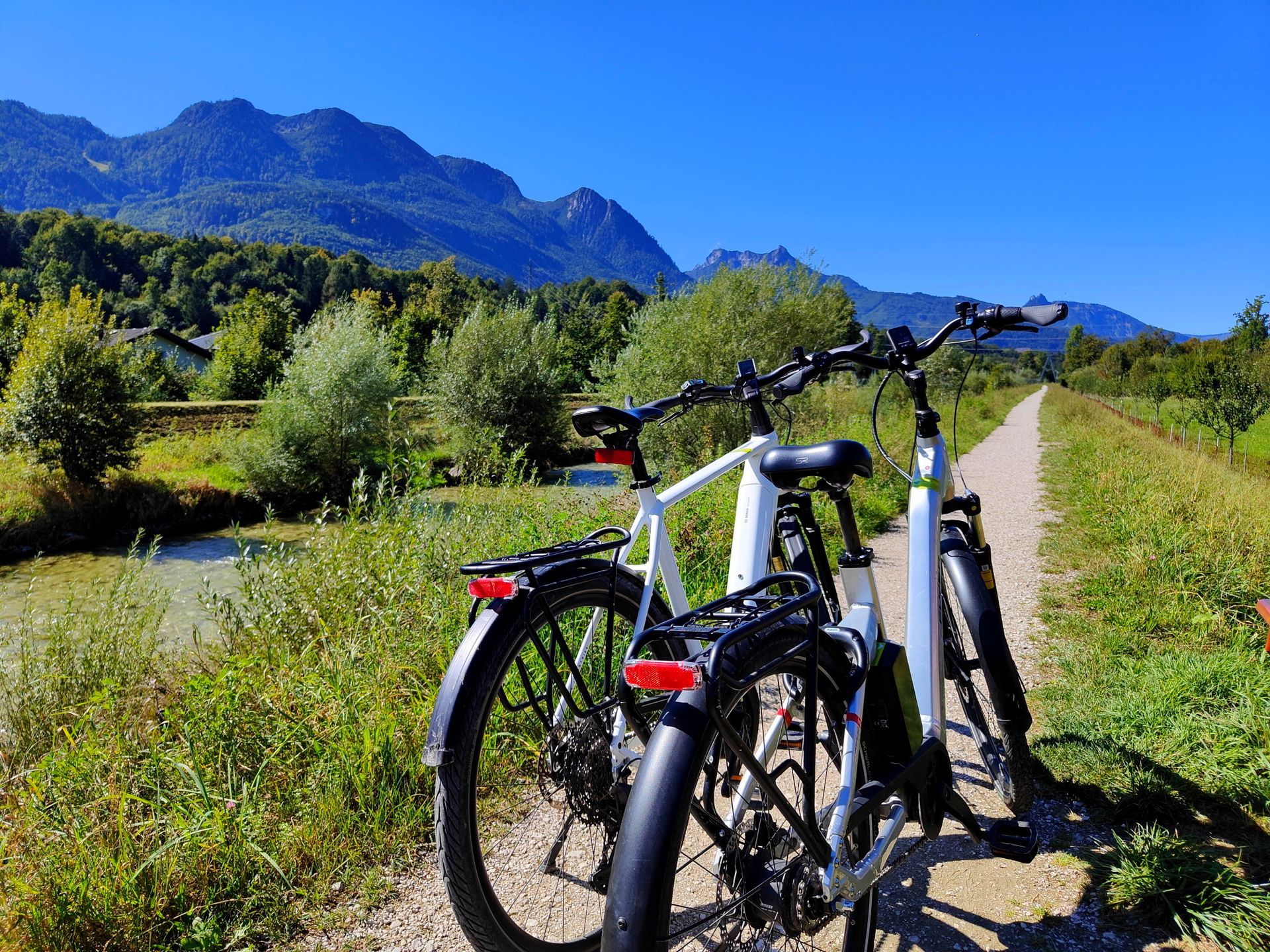 Two bicycles on a path with mountains in the background. Sunny day.