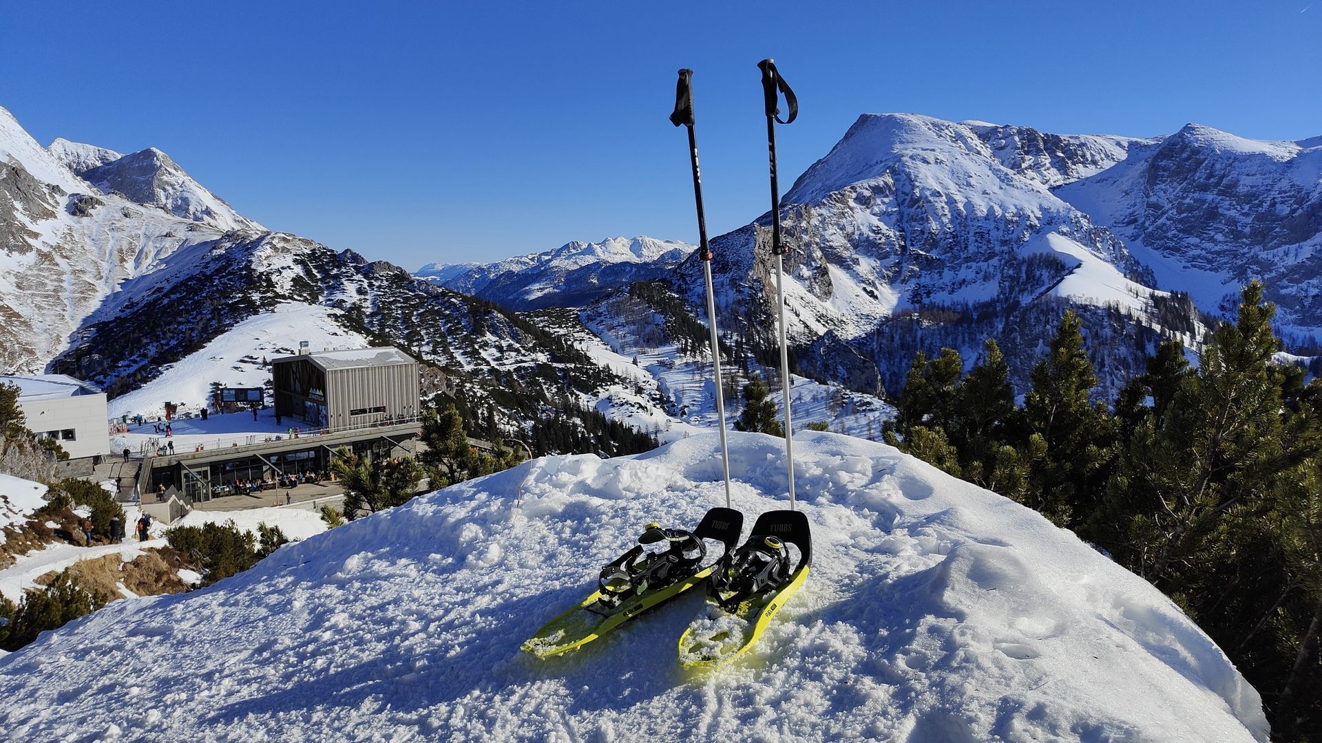 A pair of snowshoes laying on top of a snow covered mountain