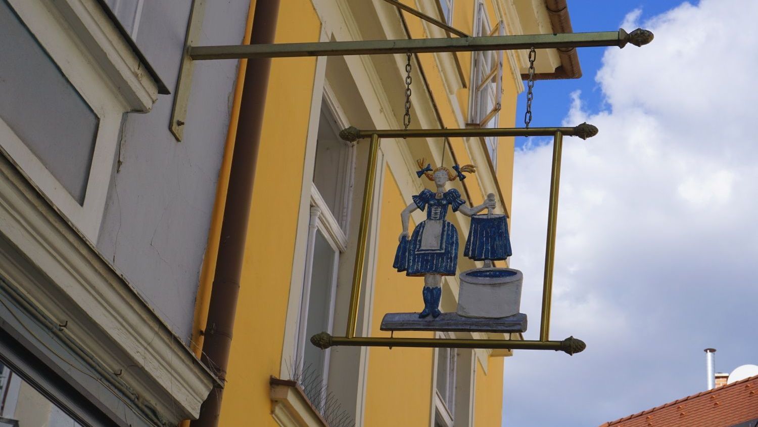 Zunftschild in Györ neben gelbem Haus